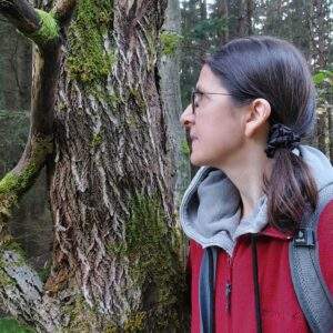 Frau im Seitenprofil vor Baum