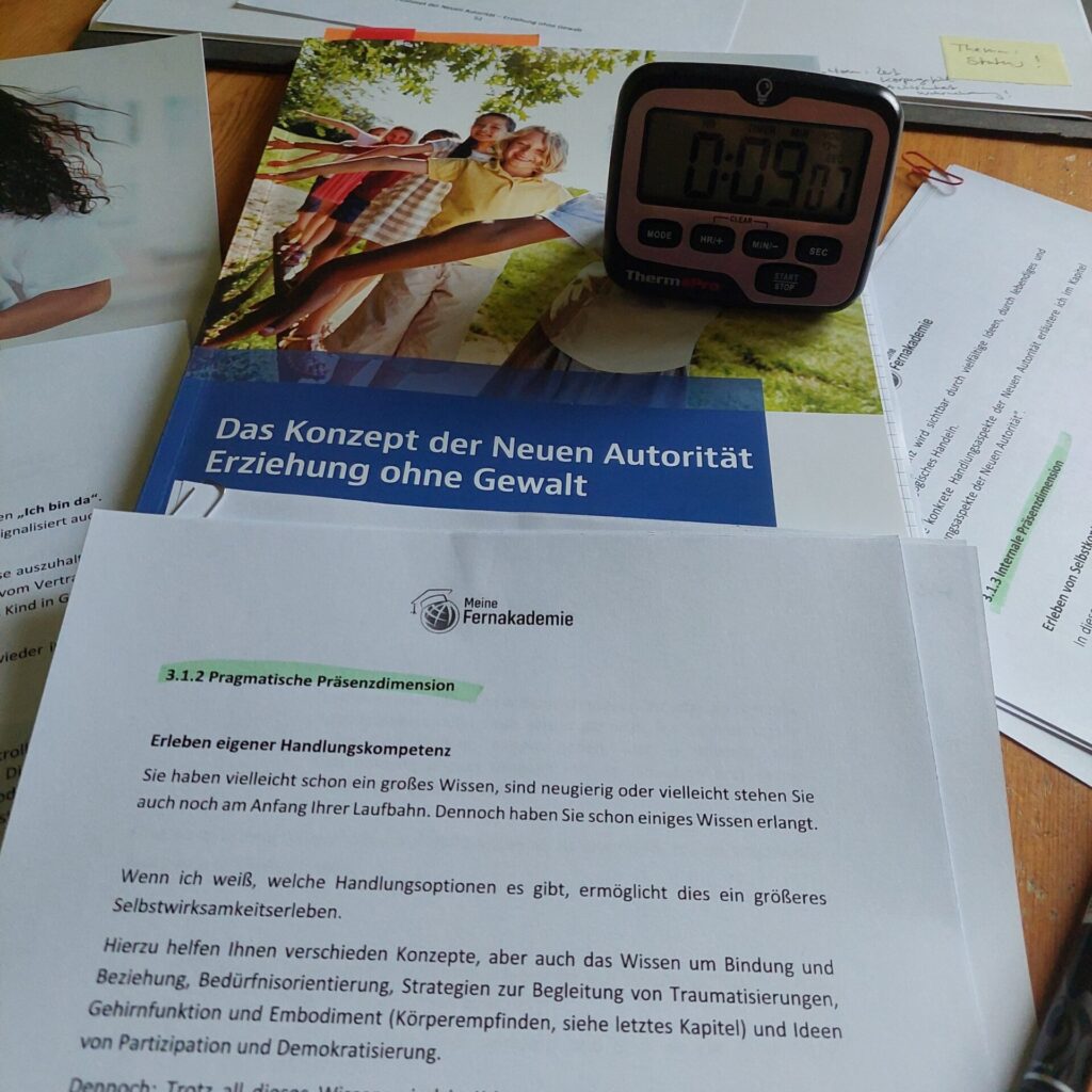 Schreibtisch mit Lernunterlagen, grün markierten Texten und einem digitalen Timer; daneben ein Stift, ein Notizblock und eine Kaffeetasse.
