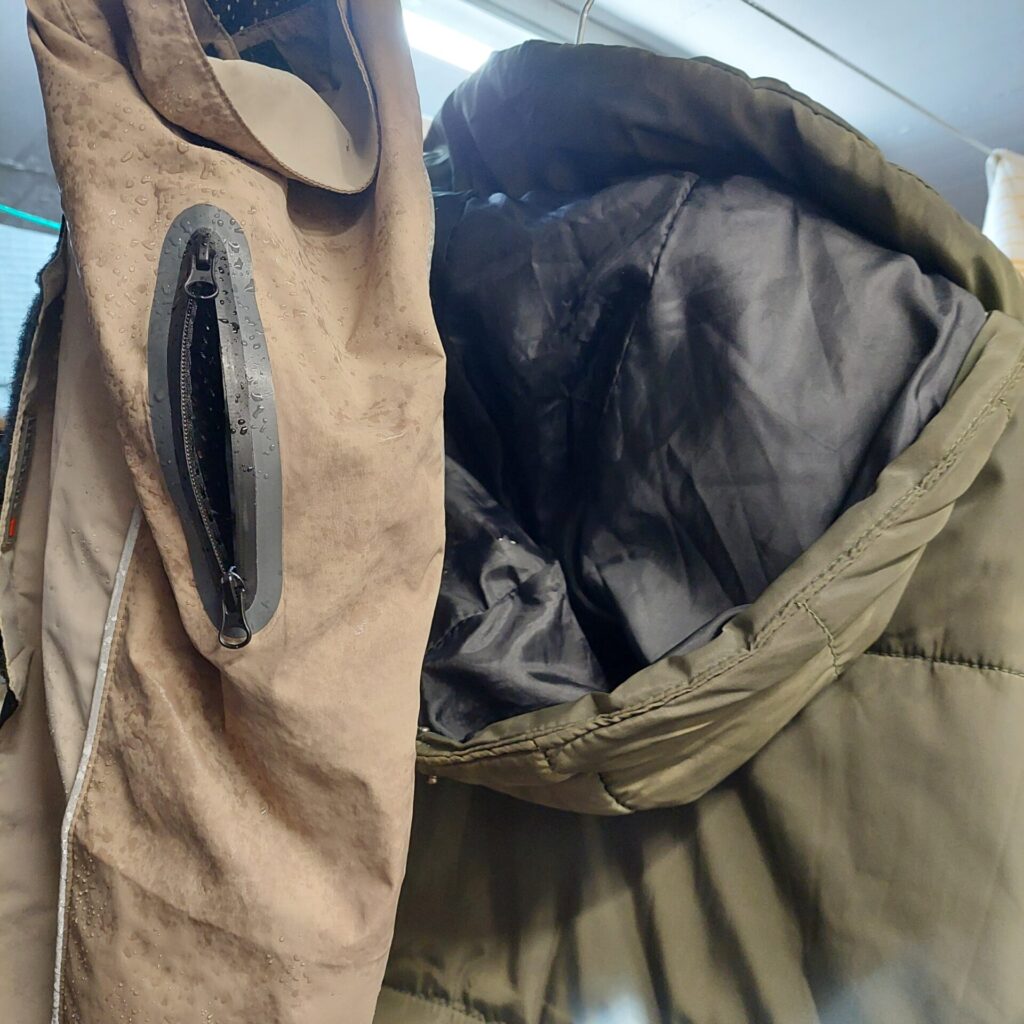 Nasser Mantel und der Regenmantel von Hündin Lotte hängen nach dem Spaziergang zum Trocknen