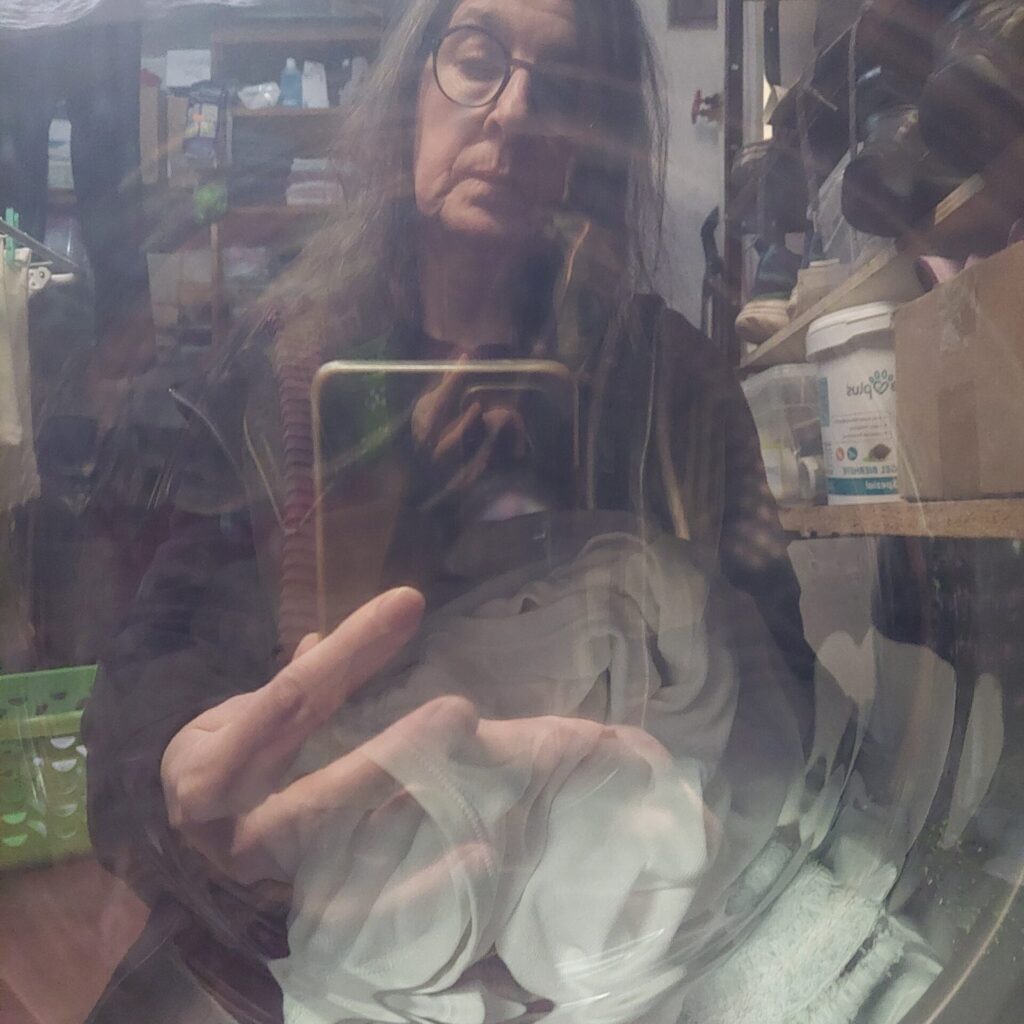 Selfie, gespiegelt in der Scheibe einer Waschmaschine.