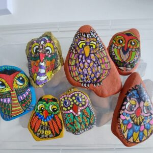 Gruppe farbenfroher Steineulen, gemeinsam arrangiert – ein Teil der Serie