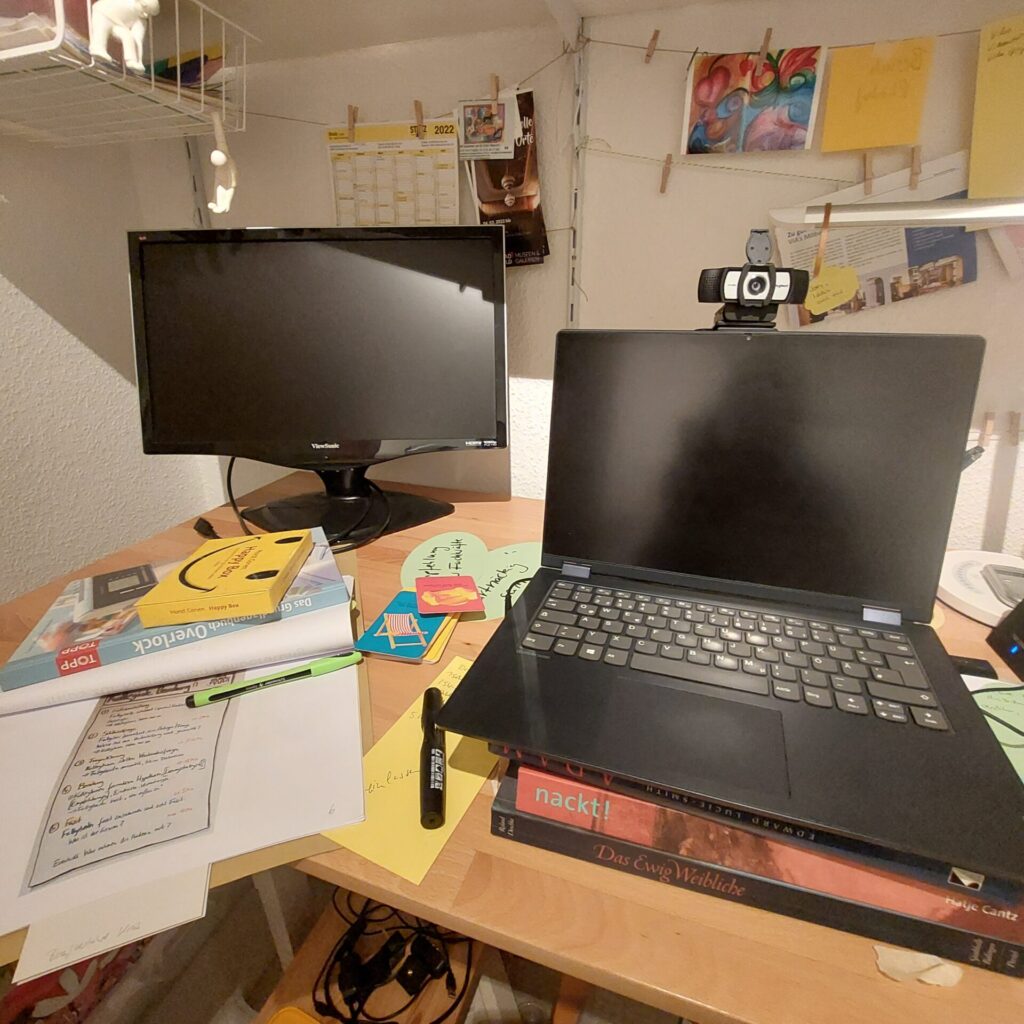 Arbeitsplatz mit Laptop, Monitor, Notizen und Büchern während der Aufbauphase von vielbegabt.de.