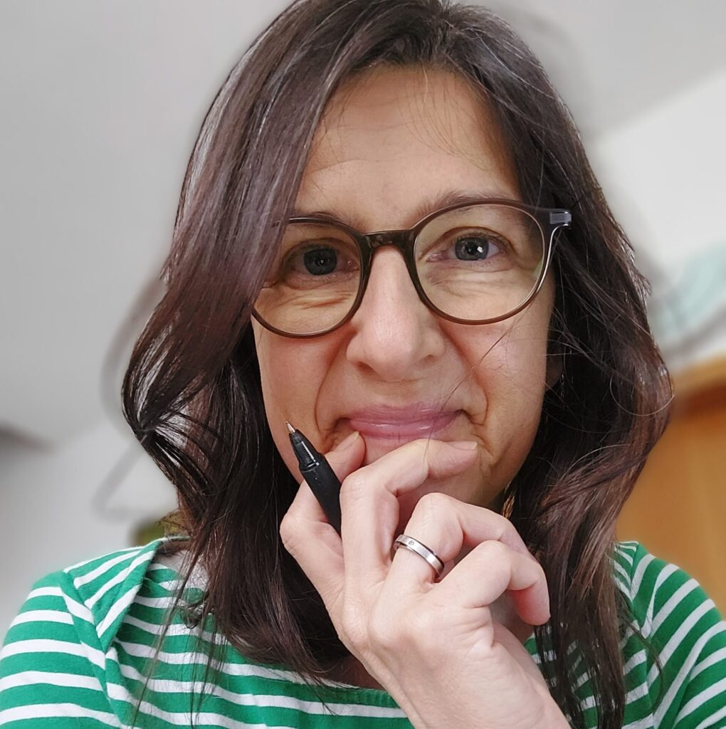 Silke Hüchel-Steinbach denkt mit einem Stift in der Hand über einen neuen Blogtext nach.