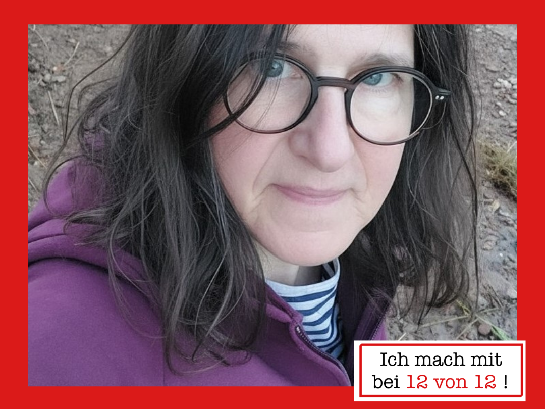 Silke mit Brille und violetter Jacke am Flussufer.