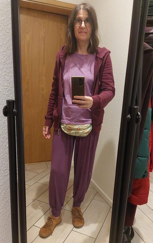 Spiegelselfie einer Frau in violettem Outfit im Flur, aufgenommen als Ausgangsbild für ein späteres Bildexperiment.